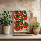 Colorful cotton twill tea towel featuring hand-illustrated red tomatoes on the vine, hanging in a bright kitchen.
