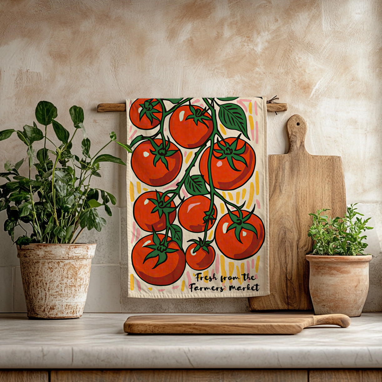 Colorful cotton twill tea towel featuring hand-illustrated red tomatoes on the vine, hanging in a bright kitchen.