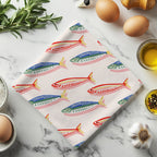 Mediterranean fish pattern tea towel displayed as a stylish coastal kitchen accessory with vibrant blue, green and coral details.