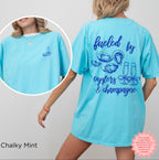 Casual coastal graphic t-shirt featuring oyster and champagne artwork inspired by seaside living