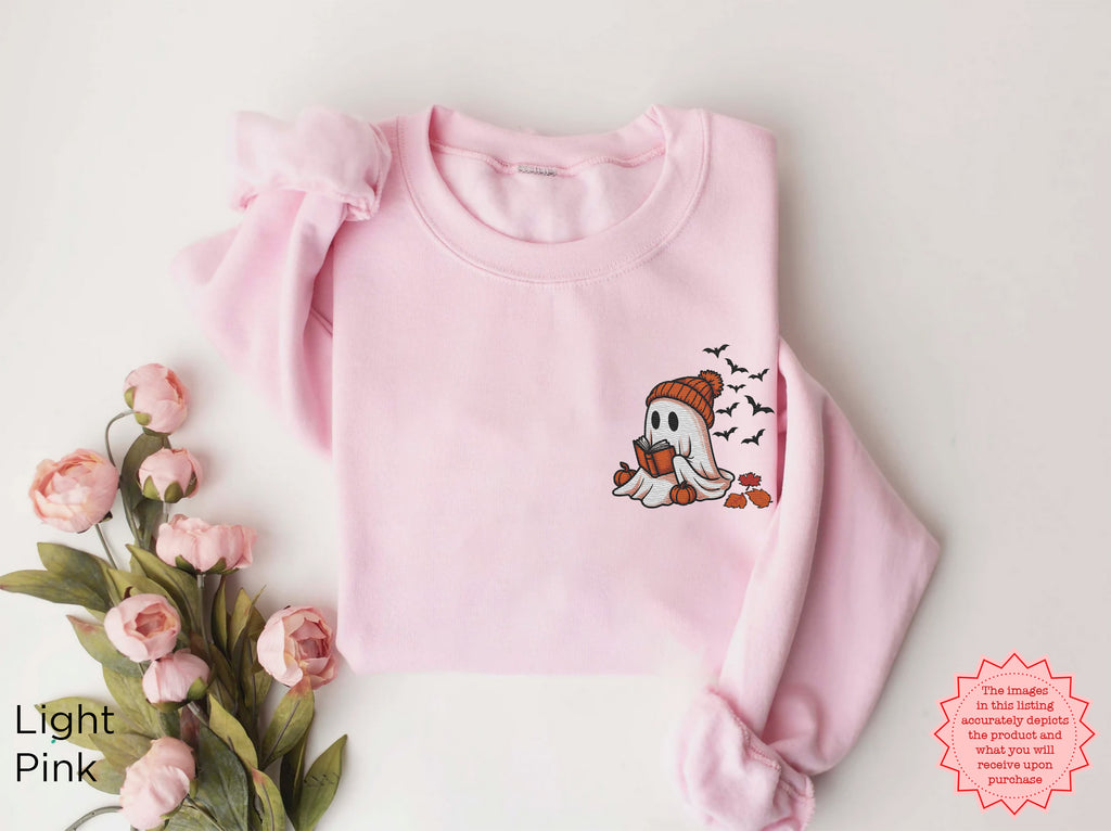 Close up of embroidered ghost reading book design on a soft dark heather sweatshirt with Halloween inspired details