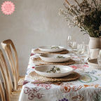 Close-up of Italian Summer Market Tablecloth showing playful illustrated seafood, lemons, pasta, vegetables and Mediterranean kitchen motifs in vibrant colours.