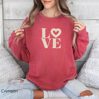 Woman wearing Crimson LOVE graphic sweatshirt with relaxed coastal style