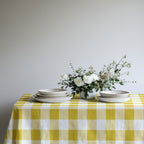 Yellow gingham cotton tablecloth adding a cheerful touch to a simple everyday dining table.