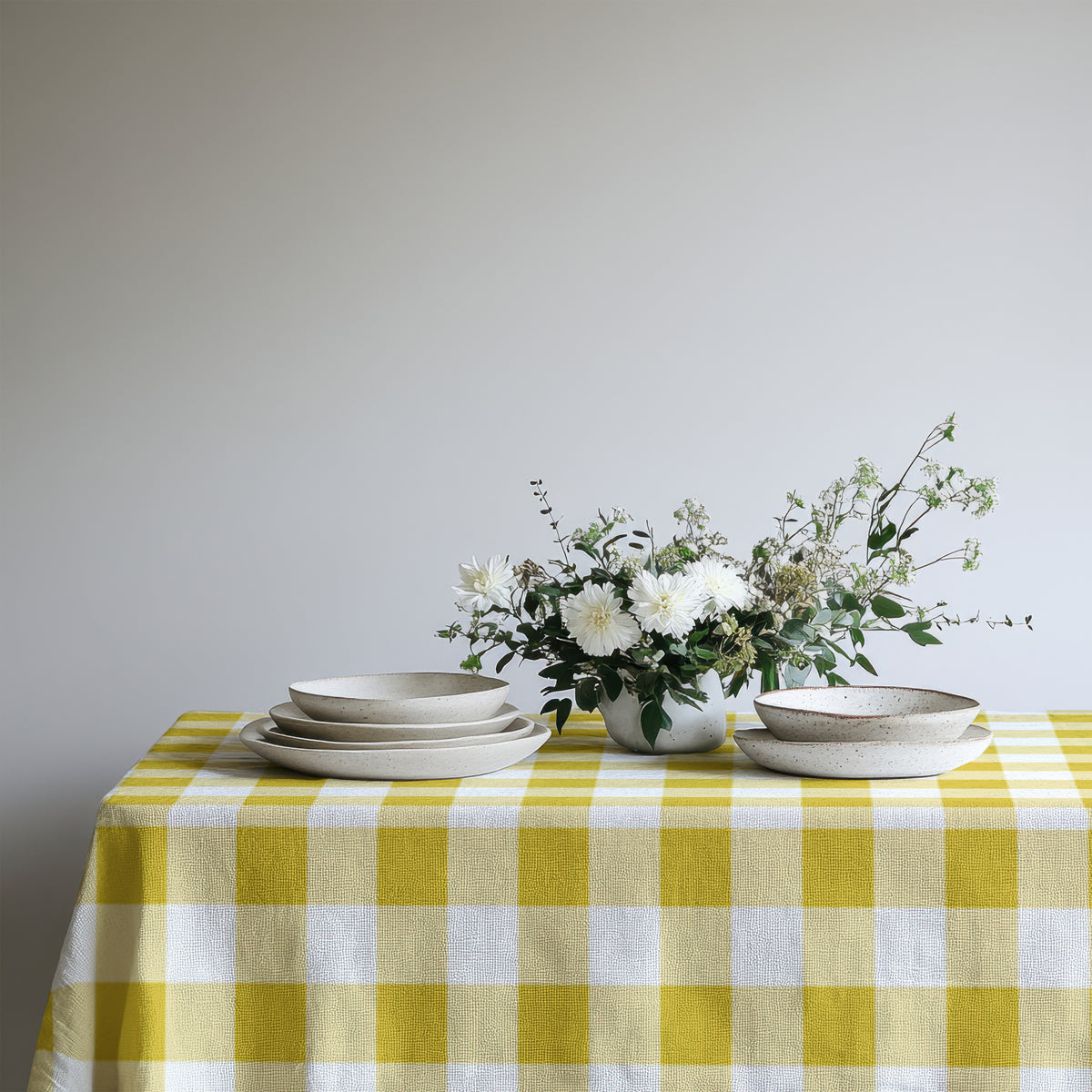 Yellow gingham cotton tablecloth adding a cheerful touch to a simple everyday dining table.