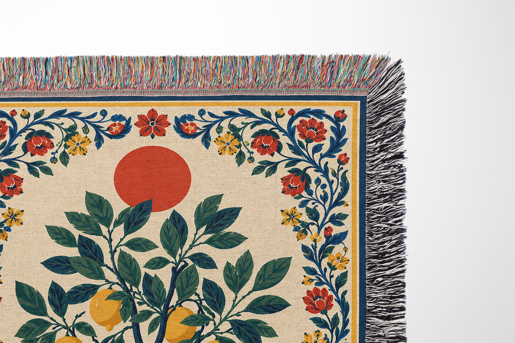 Close-up view of woven thread texture and colorful fringed edges on a botanical cotton throw blanket