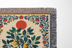 Close-up view of woven thread texture and colorful fringed edges on a botanical cotton throw blanket