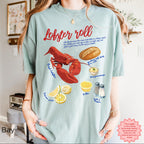Unisex Comfort Colors 1717 t-shirt in Bay blue with colorful lobster roll graphic, fresh lobster, bread, lemon, and condiments illustration, styled for coastal seafood lovers.