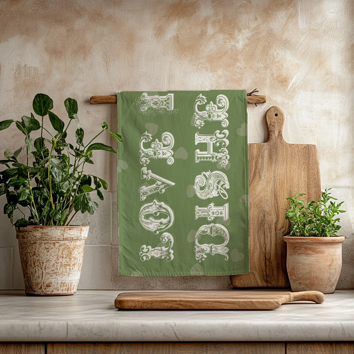Decorative olive green tea towel styled with wooden utensils and herbs