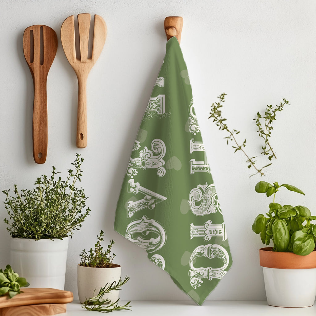 Folded olive green kitchen tea towel on marble surface with cooking ingredients