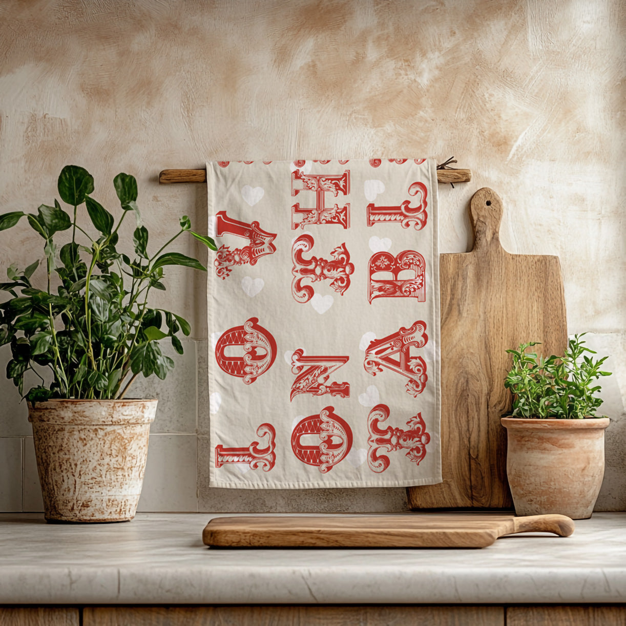 Cream kitchen tea towel with vintage red typography hanging in a neutral kitchen