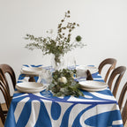 Rectangle blue artistic tablecloth layered with glassware and natural textures