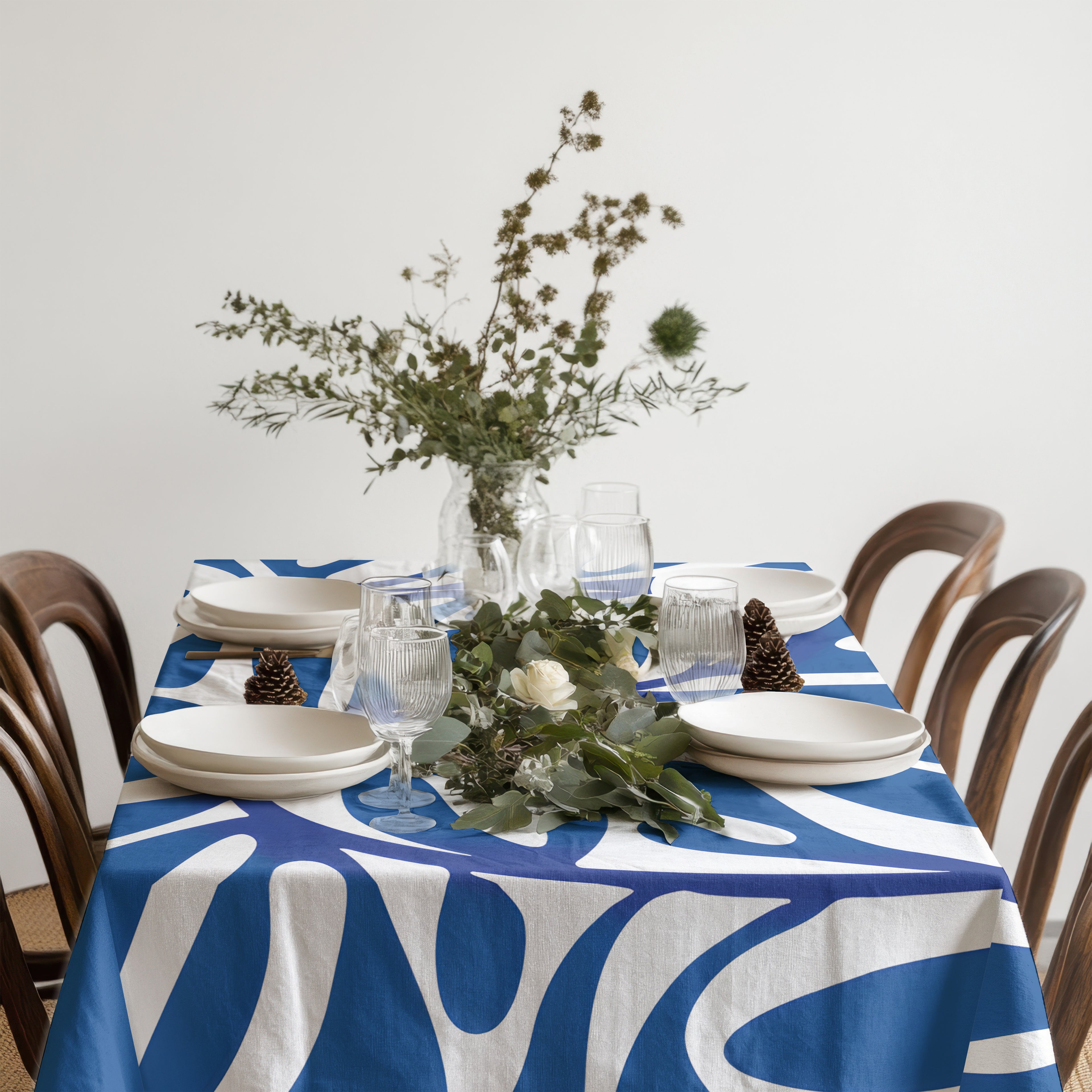 Rectangle blue artistic tablecloth layered with glassware and natural textures