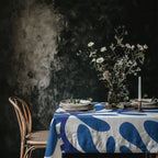 Blue Matisse inspired cotton twill tablecloth styled on a dark moody dining table with floral centrepiece