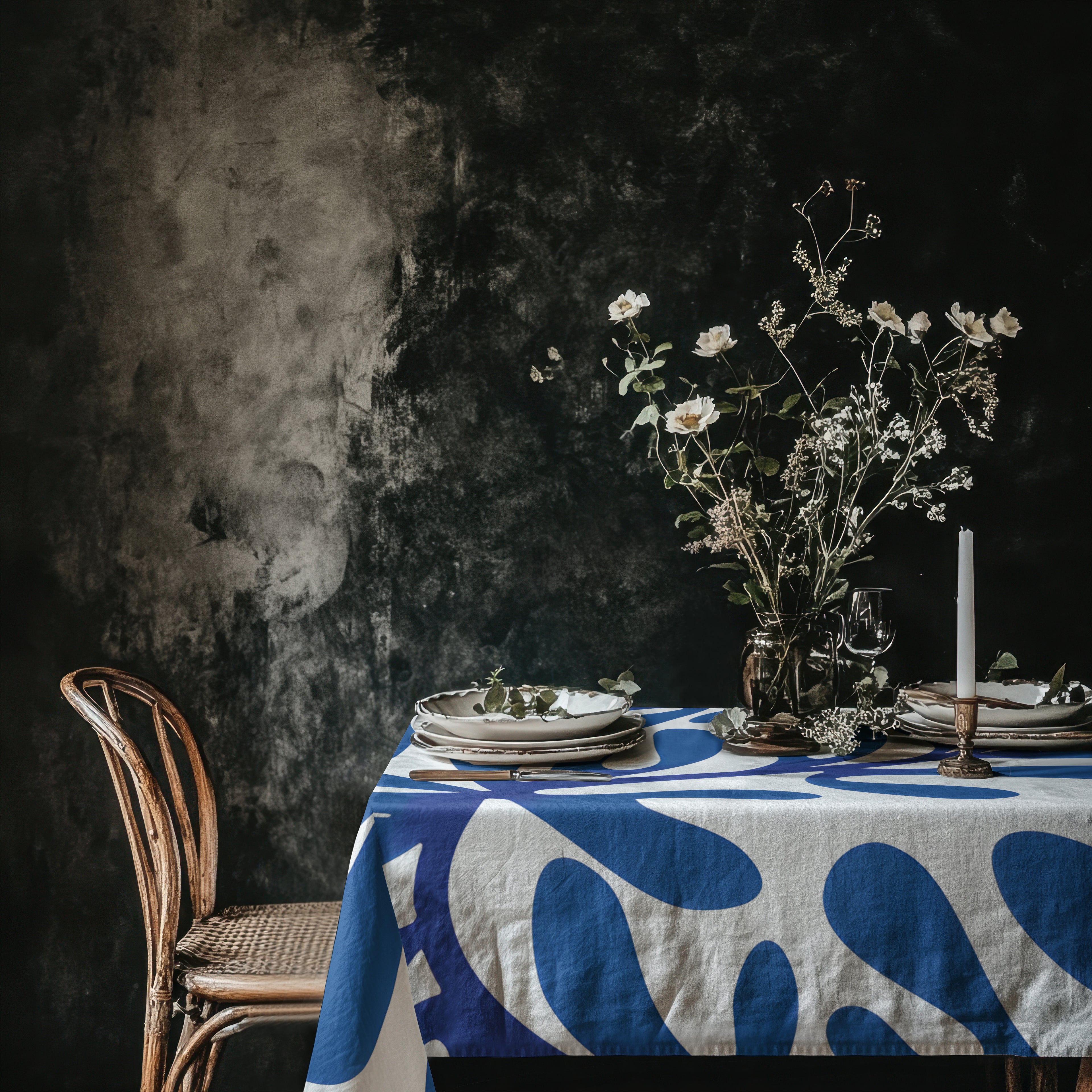 Blue Matisse inspired cotton twill tablecloth styled on a dark moody dining table with floral centrepiece