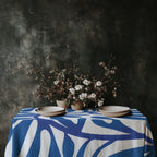 Square blue cotton twill tablecloth shown in an elevated contemporary dining setting