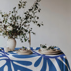 Mediterranean style dining table featuring a modern blue statement tablecloth