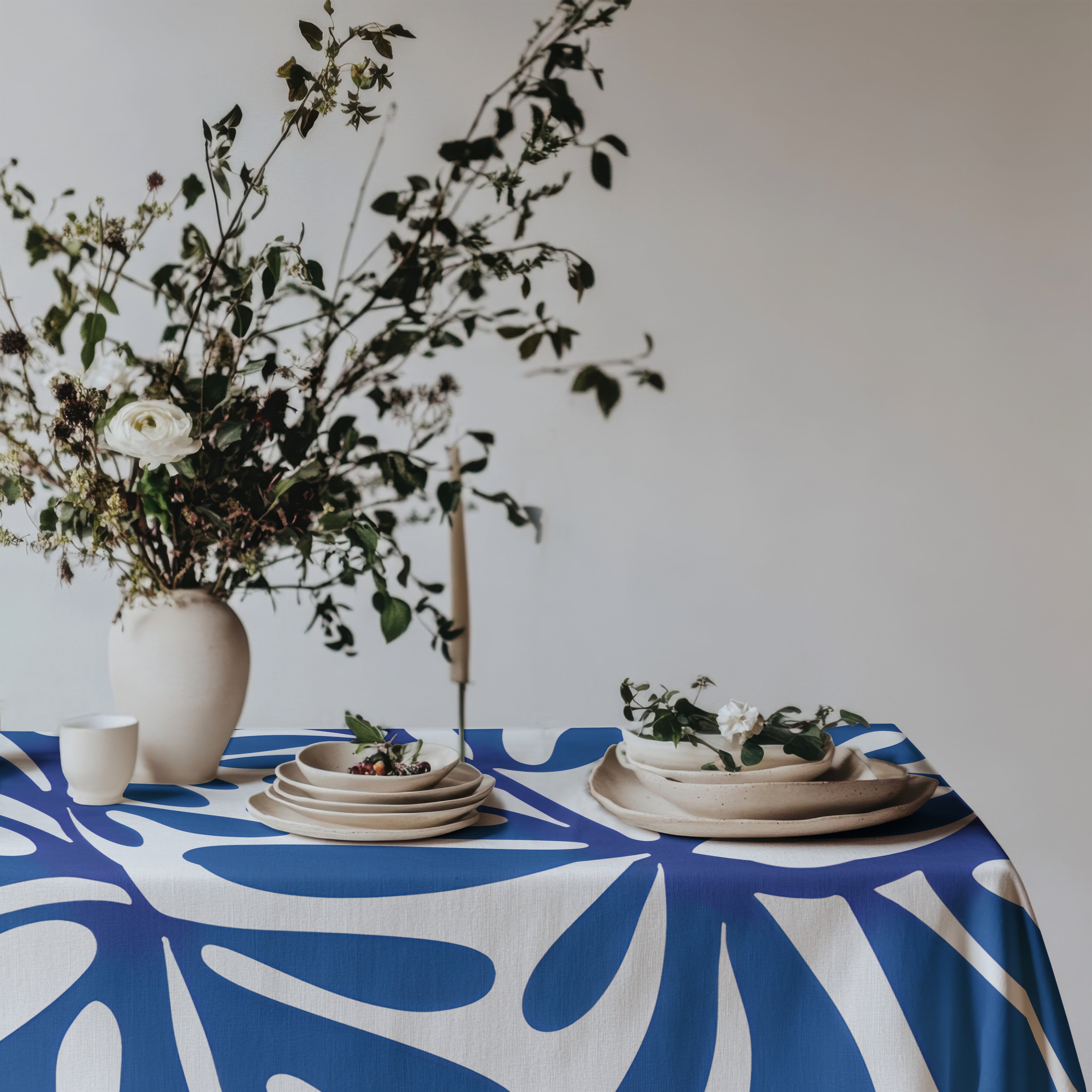 Mediterranean style dining table featuring a modern blue statement tablecloth