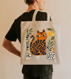 Coastal-inspired cat tote bag featuring Mediterranean olives, lemons, ceramic tile patterns, and modern folk art design.