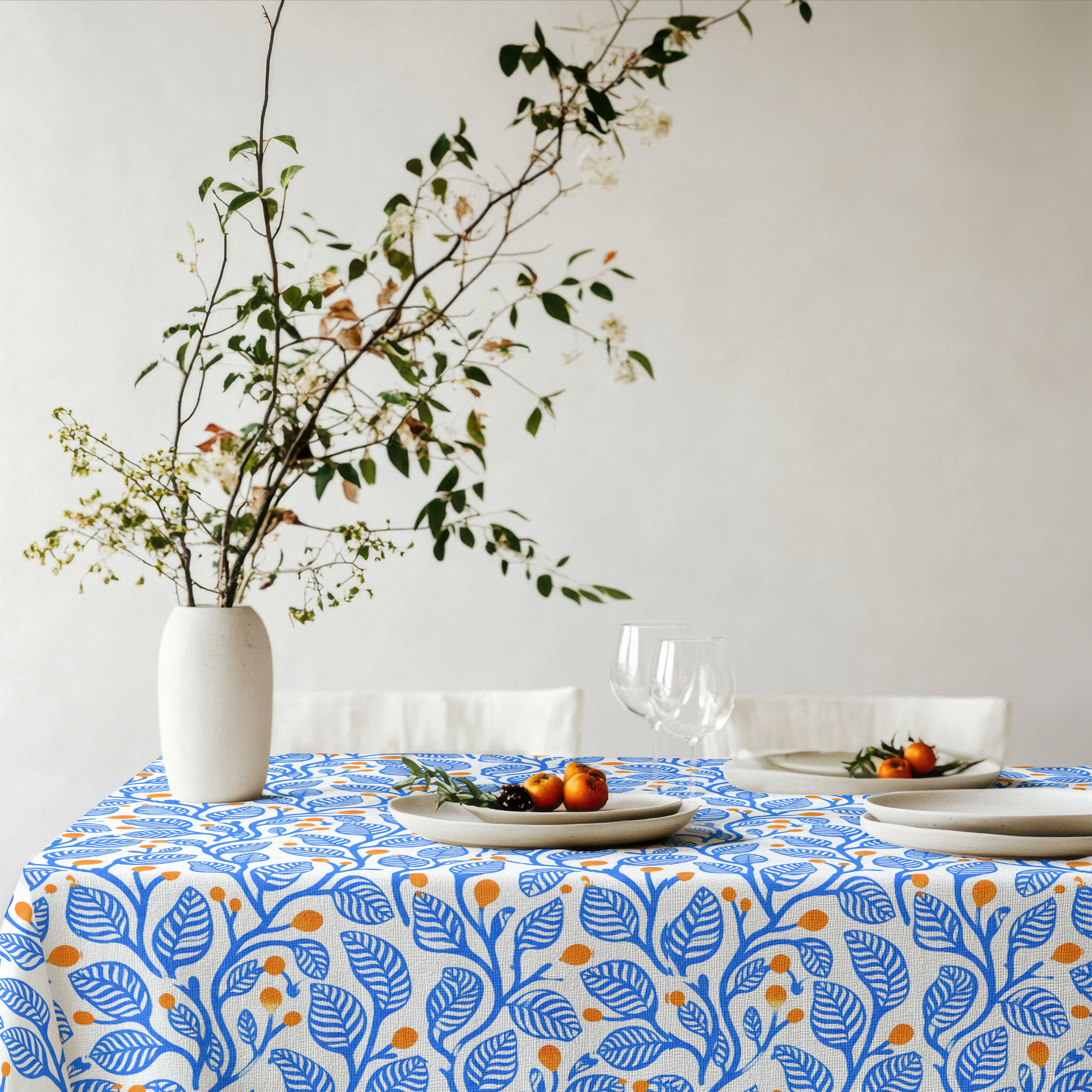 Mediterranean Botanica Tablecloth featuring a blue botanical leaf pattern with warm terracotta accents on premium 100% cotton twill.