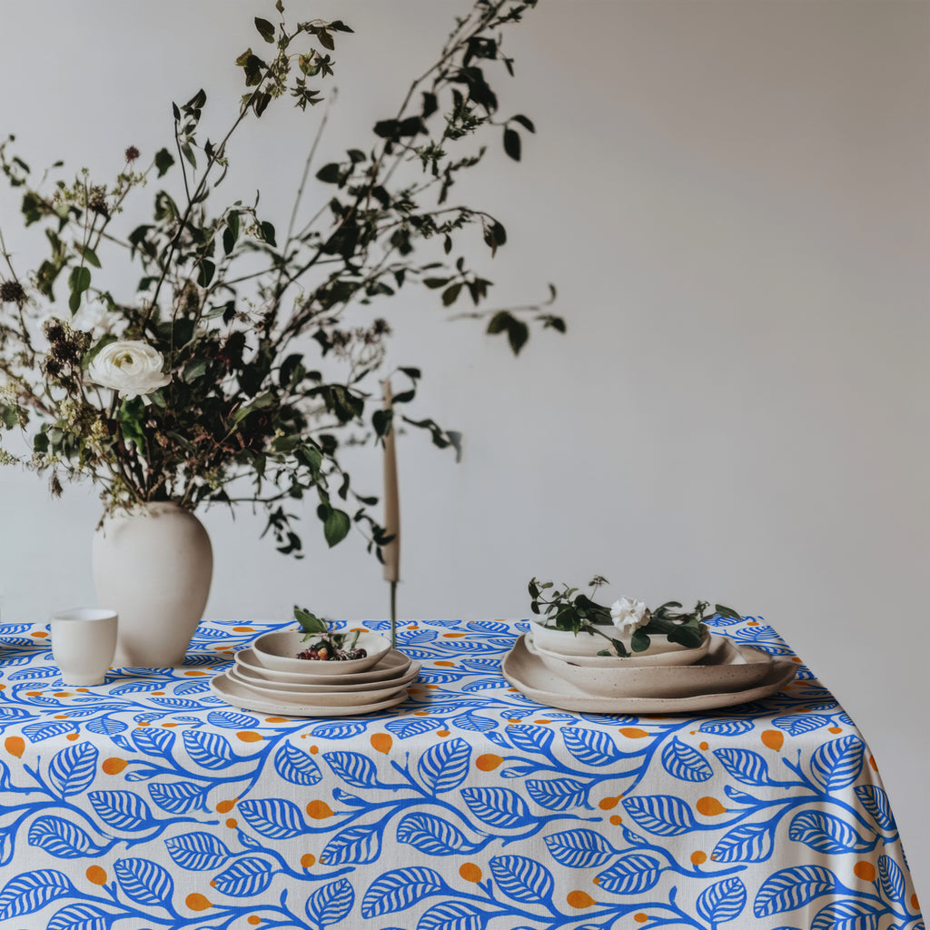 Premium 100% cotton twill tablecloth featuring a modern Mediterranean botanical print in blue and terracotta.
