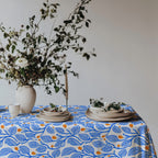 Premium 100% cotton twill tablecloth featuring a modern Mediterranean botanical print in blue and terracotta.