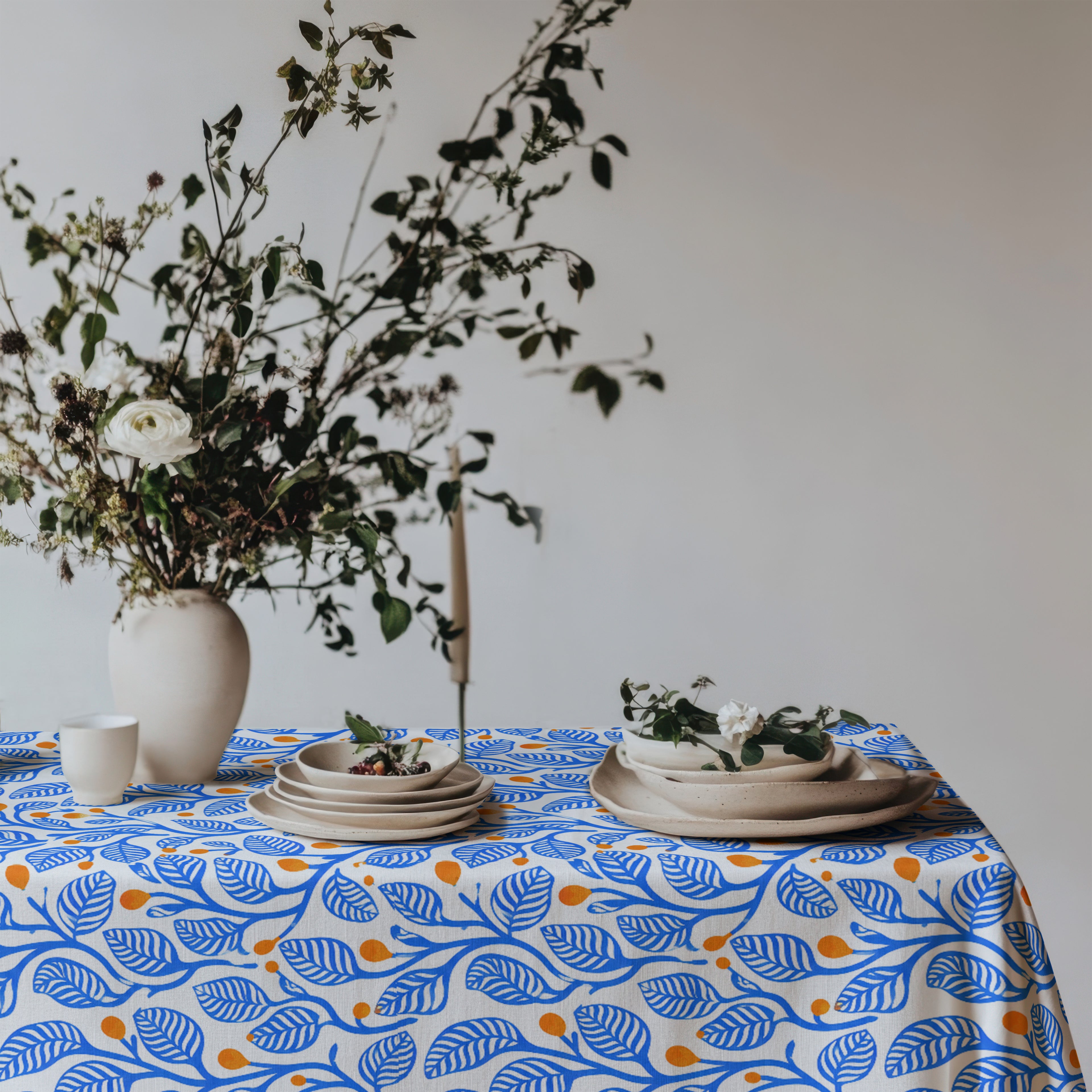 Premium 100% cotton twill tablecloth featuring a modern Mediterranean botanical print in blue and terracotta.