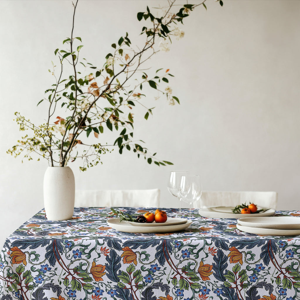 Styled dining setting with Mediterranean floral tablecloth, plates, glassware, and natural decor.
