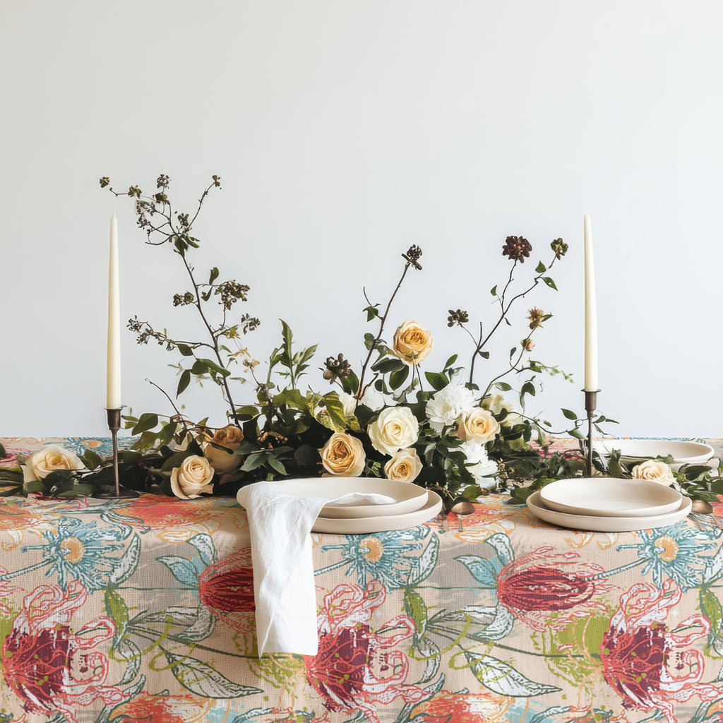 Colorful floral cotton twill tablecloth styled in moody dining room with candles, rustic chair, and botanical arrangement