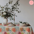 Artful Mediterranean tablecloth featuring vibrant florals styled with neutral stoneware and natural textures