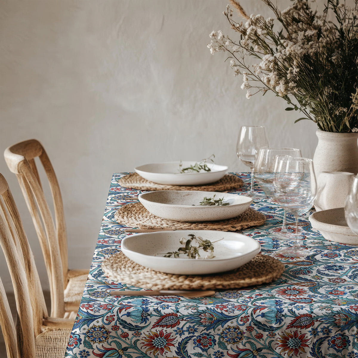 Blue and turquoise Mediterranean floral tablecloth styled with white ceramic dinnerware