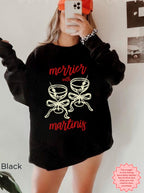 Black Gildan 18000 crewneck sweatshirt with the “Merrier with a Martini” funny Christmas cocktail graphic, holiday party outfit.