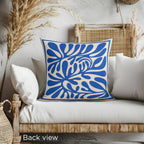 Modern Mediterranean decorative cushion with bold cobalt blue abstract leaf pattern and soft neutral background.