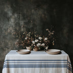 Blue heritage stripe cotton twill tablecloth creating a refined French Riviera dining atmosphere with rustic ceramics, natural textures, and European farmhouse styling.
