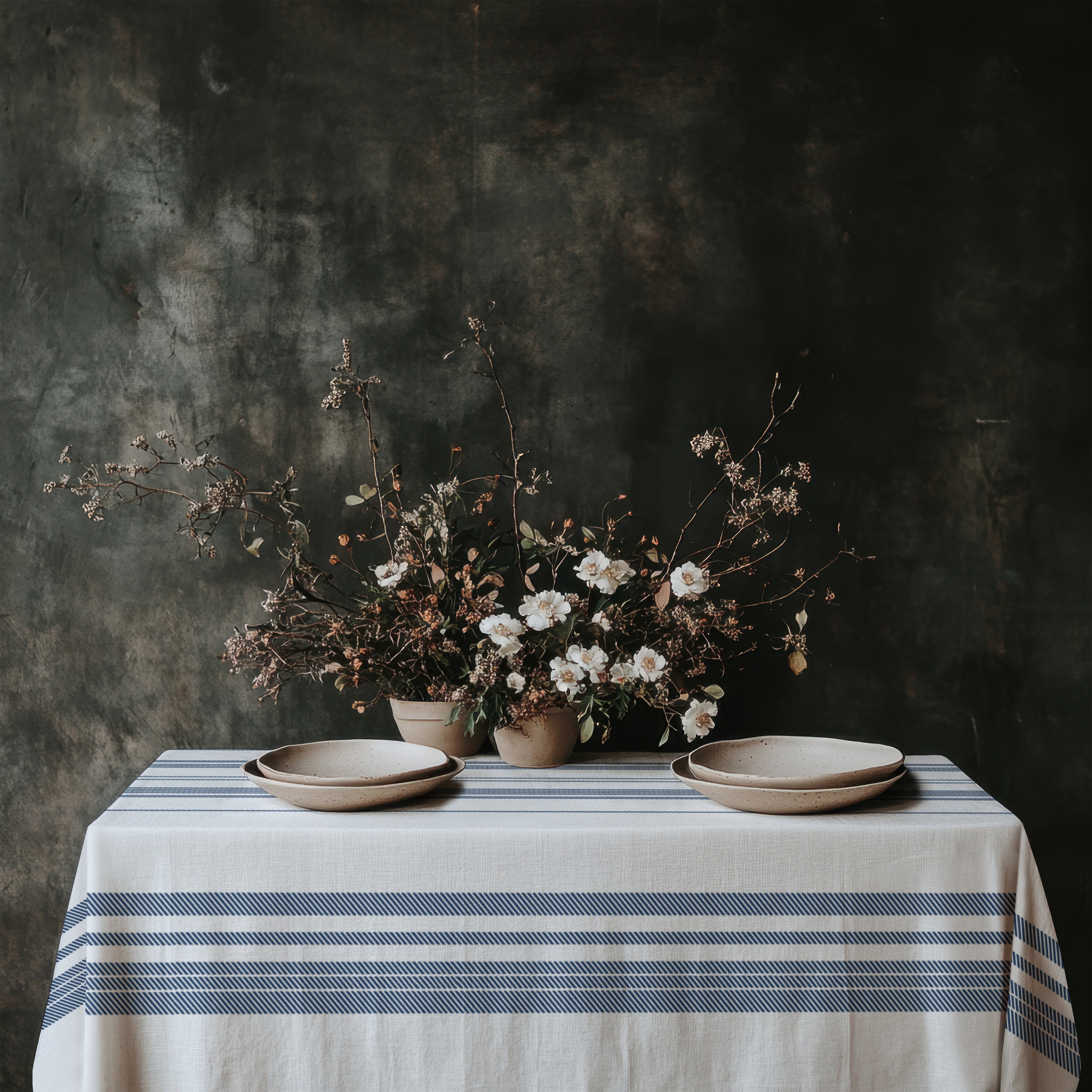 Blue heritage stripe cotton twill tablecloth creating a refined French Riviera dining atmosphere with rustic ceramics, natural textures, and European farmhouse styling.