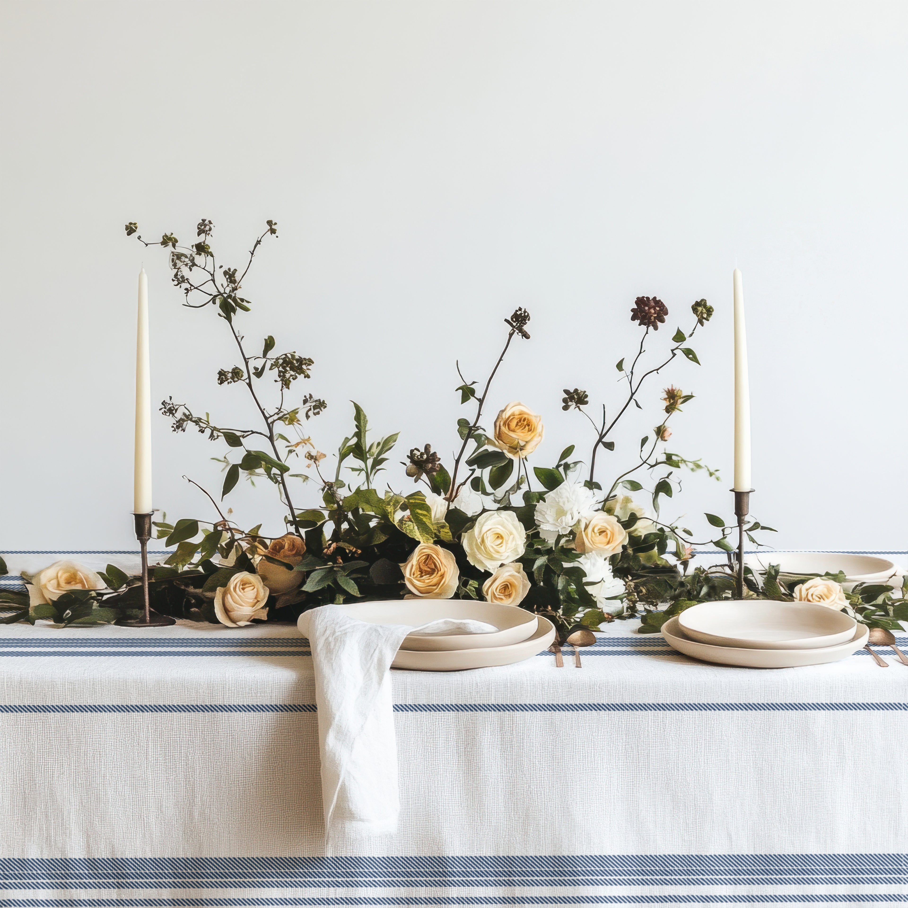 Modern Mediterranean dining table featuring a blue striped cotton tablecloth inspired by French countryside interiors and coastal European homes.