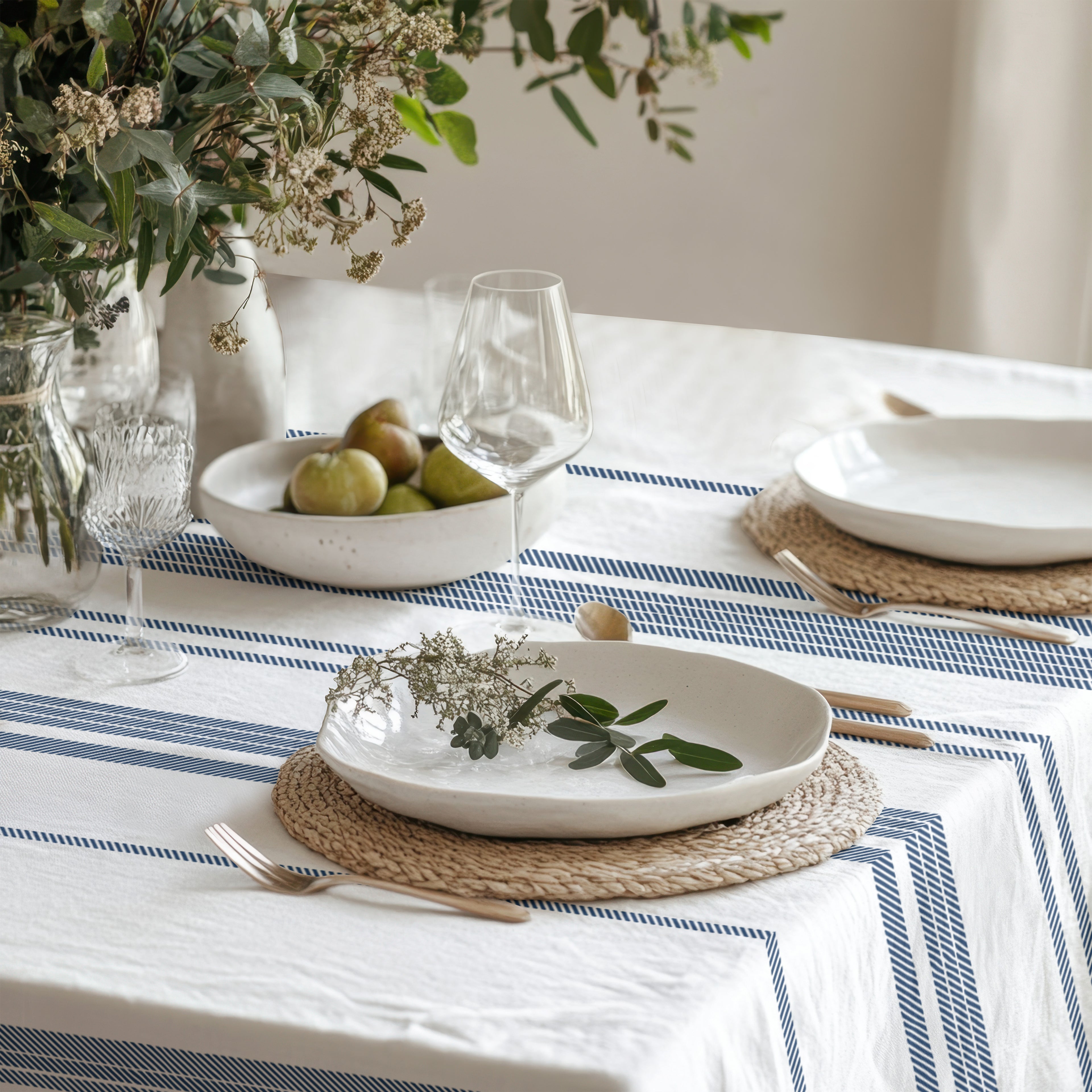 Elegant blue stripe table linen styled with handmade ceramic plates, dried flowers, and natural décor for a timeless European tablescape.