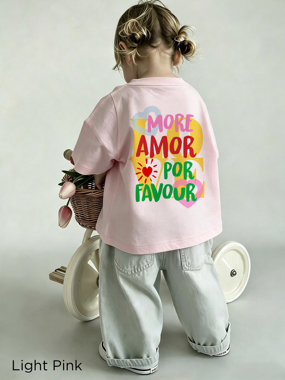 Colourful More Amore Por Favour graphic on the back of a Light Pink toddler T-shirt, featuring playful lettering and heart details.