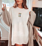 Soft Ivory Oh La La embroidered boho t-shirt for women, handmade artisanal cotton tee, eco-conscious Comfort Colors 1717, casual Instagram-ready free-spirited outfit