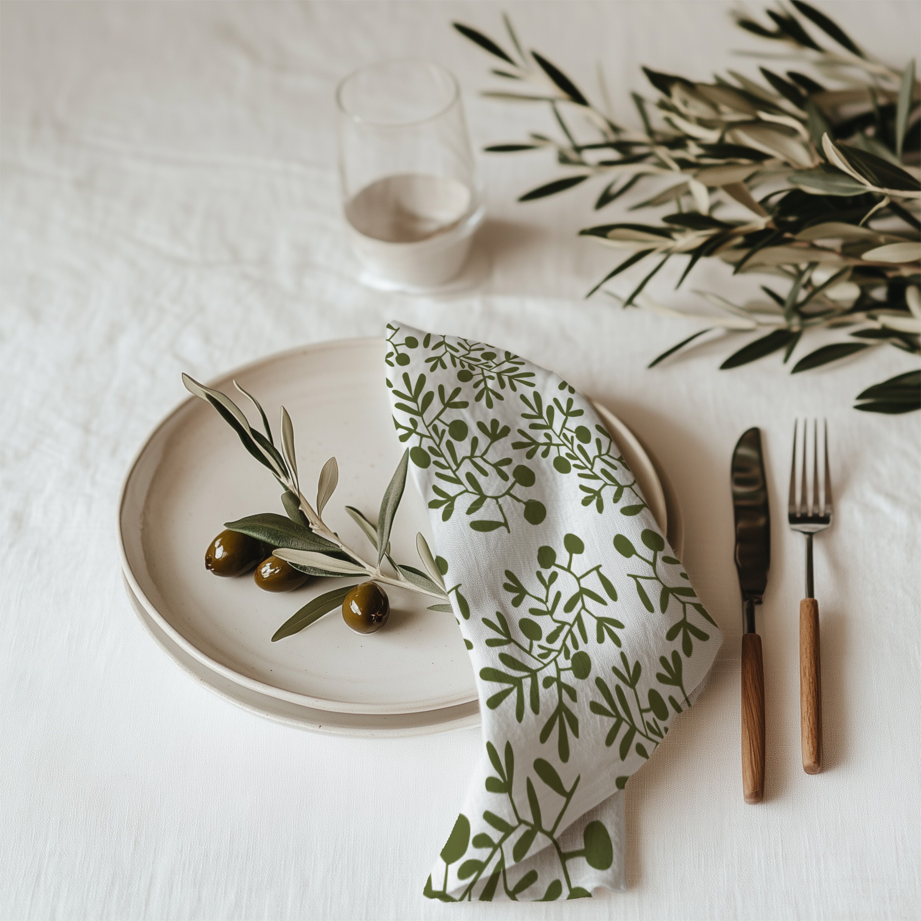 Hand drawn olive branch cotton twill cloth napkin displayed on elegant dining table with botanical home decor