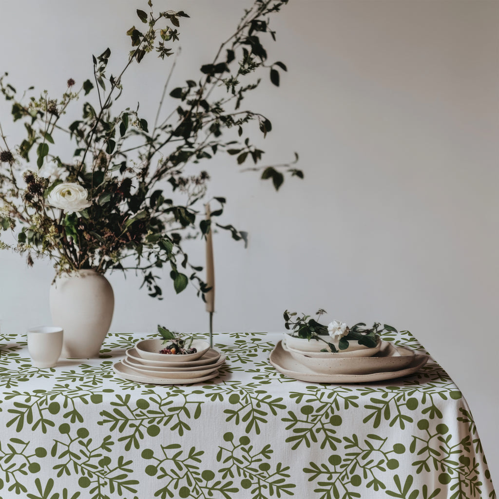 Mediterranean-inspired dining table featuring botanical olive tablecloth and neutral home décor.