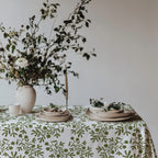Mediterranean-inspired dining table featuring botanical olive tablecloth and neutral home décor.