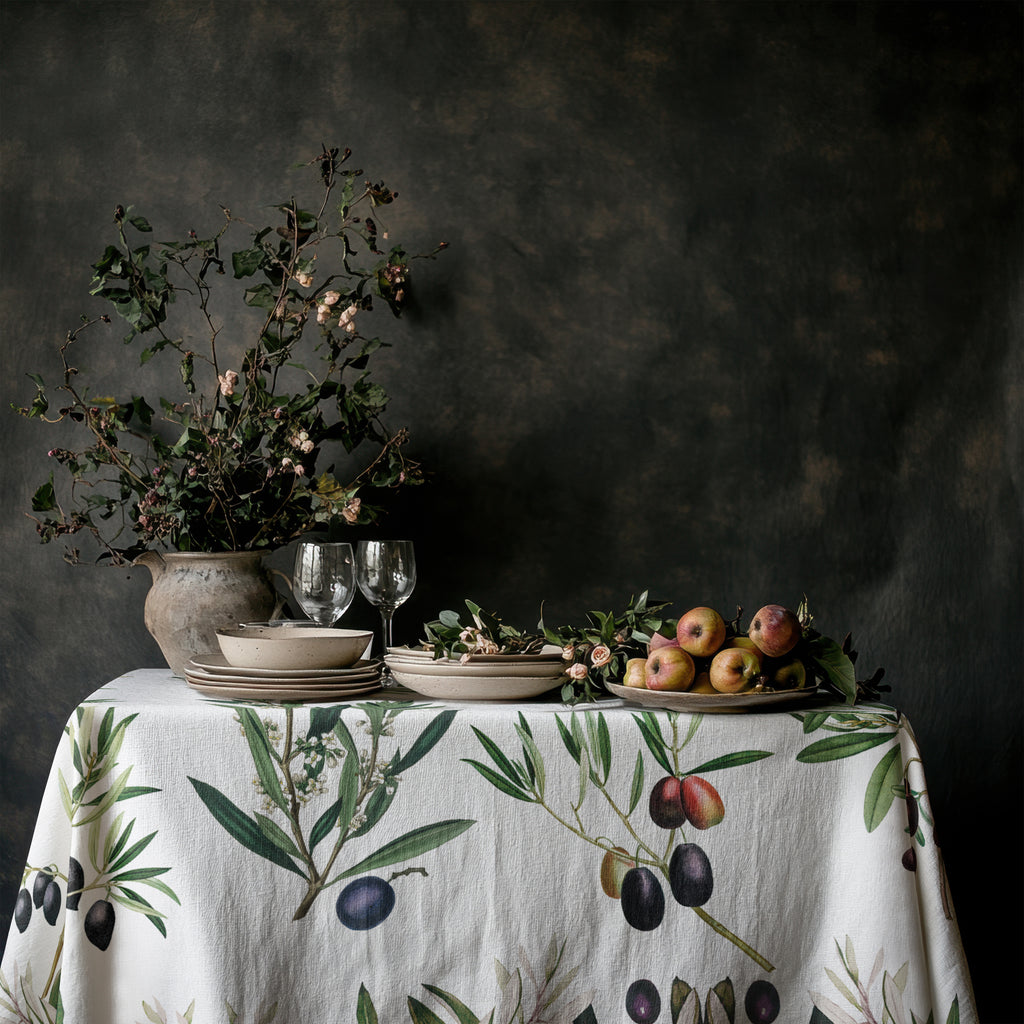 Mediterranean Olive Branch Tablecloth - Soft cotton twill featuring hand-painted olive branch illustrations. The fresh, natural pattern complements a minimalistic dining table with neutral tones.