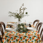 Citrus dining table linen featuring oranges, blossoms, and leaves inspired by European summer living.