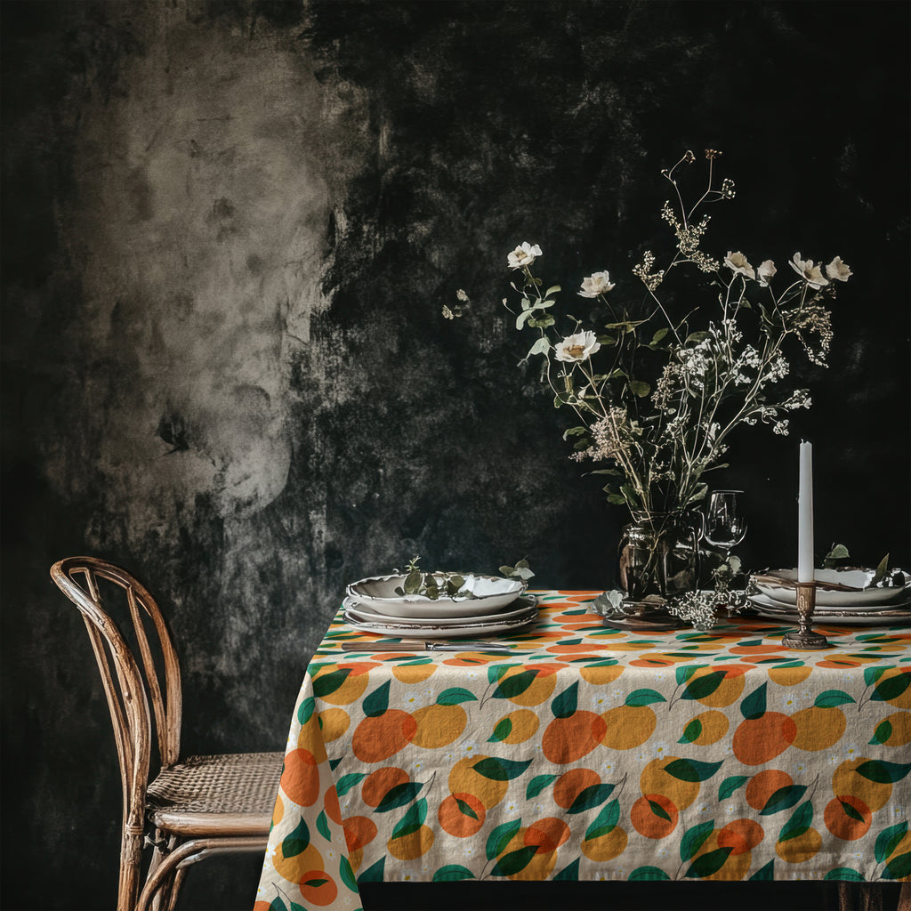 Mediterranean-inspired dining table styled with a citrus pattern tablecloth and elegant floral centerpiece.