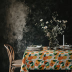 Mediterranean-inspired dining table styled with a citrus pattern tablecloth and elegant floral centerpiece.
