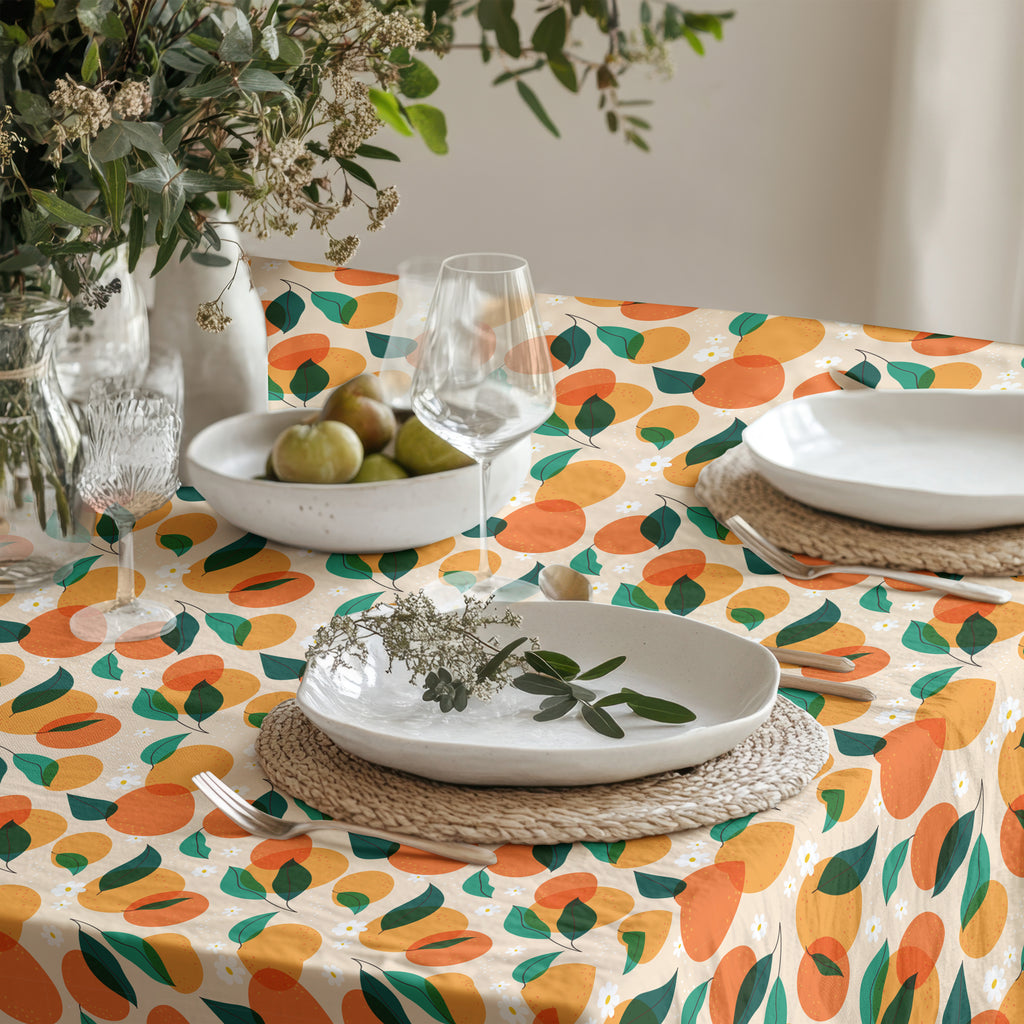 Colorful orange grove tablecloth featuring vibrant citrus fruit and green leaves on premium cotton twill fabric.