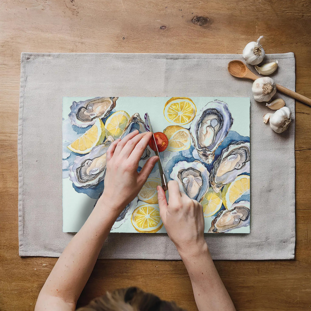 Watercolor seafood and citrus kitchen decor featuring oysters and lemons on a tempered glass cutting board
