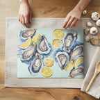 Watercolor oysters and lemons glass cutting board featuring coastal kitchen artwork on textured tempered glass