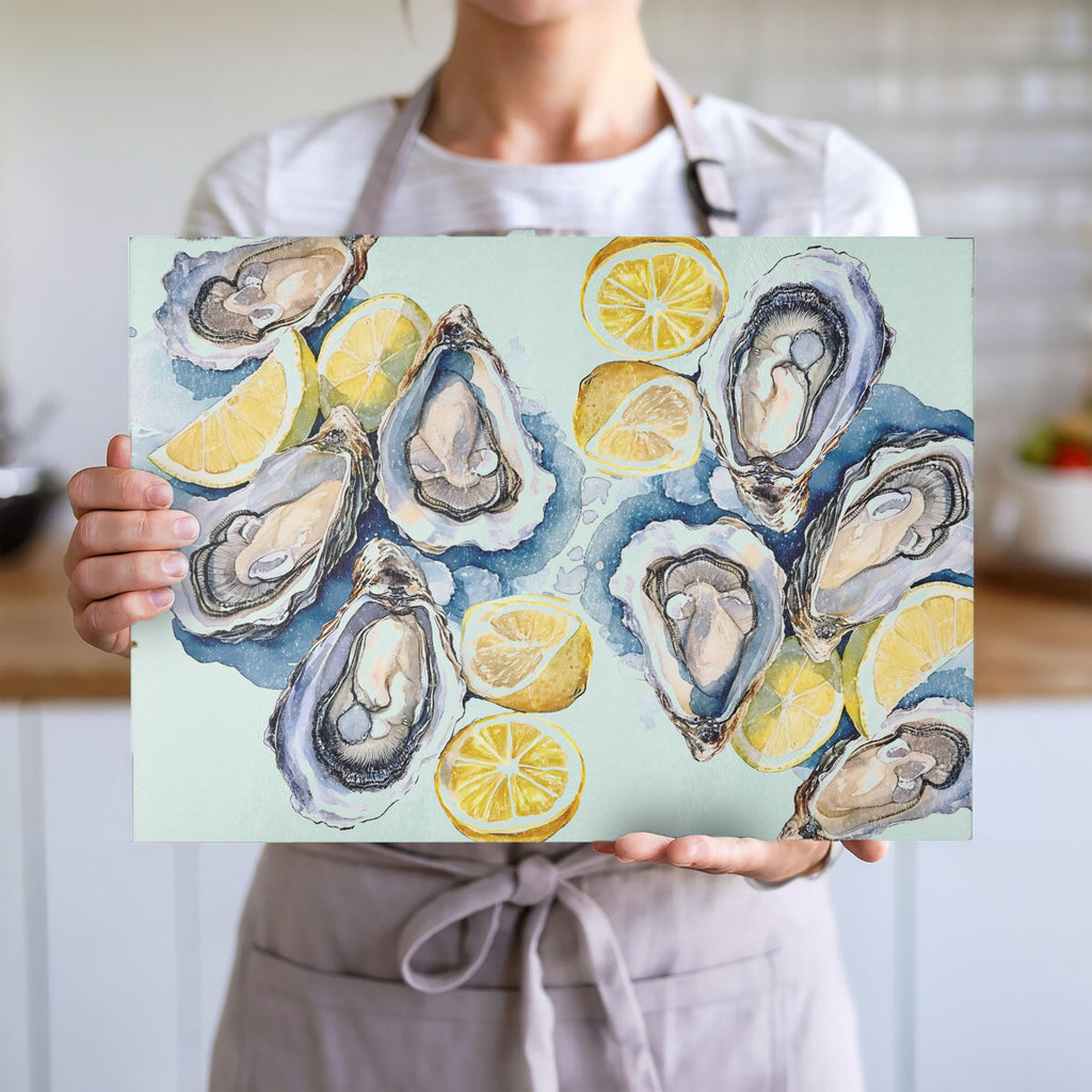 Coastal-inspired glass cutting board with hand-painted style oysters, lemons and soft seaside watercolor tones